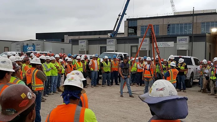 Construction crew gathered for a jobsite safety briefing